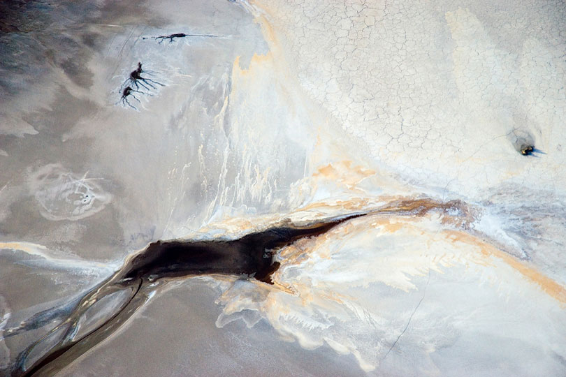 Springs form dark patches and abstract patterns on the shore<p> of Lake Natron, Tanzania