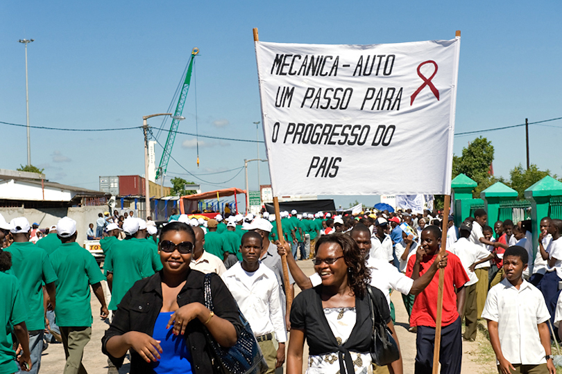 1st of May rally workers carry a banner with <p>HIV/AIDS ribbon to create awareness